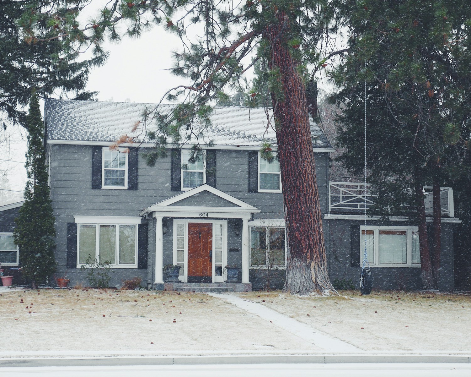 gray and white wooden house near green leaf tree